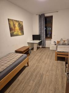 a room with two beds and a desk with a computer at Privat Apartment 2 Leoben in Leitendorf