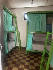 2 letti a castello in una camera con pavimento a scacchi di Hostal Casa La Merced a Antigua Guatemala