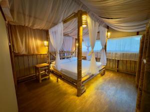 a bedroom with a canopy bed with a wooden floor at Los Pinos EcoHotel in Villa Restrepo