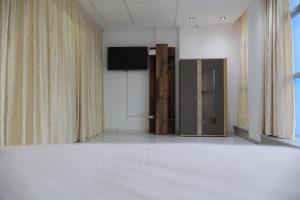 a room with a television and a door with curtains at Chic Studio in the Heart of Kenitra in Kenitra