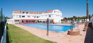 a swimming pool in front of a white building at Apartamentos Telleira in Nigrán