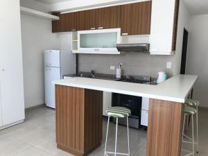 a kitchen with a counter and stools in it at Departamento Barrio Plaza Colon in Chivilcoy +7 photos