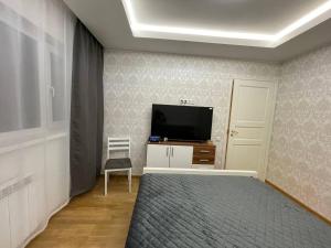 a bedroom with a bed and a tv on a wall at Mõisavahe apartment in Tartu