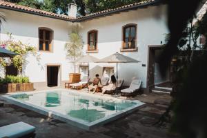 dos personas sentadas bajo sombrillas frente a una casa en Batucada Hotel Boutique, en Valle de Bravo