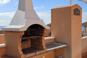 an outdoor pizza oven on top of a building at Ático con vistas al Mediterráneo in Isla Plana