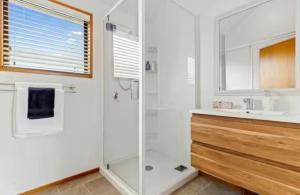 a white bathroom with a shower and a sink at Homestay near CHC Airport in Christchurch