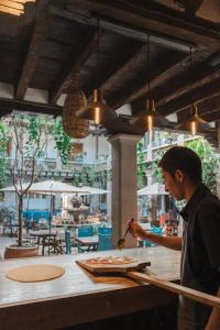 a man preparing food at a counter in a restaurant at Batucada Hotel Boutique in Valle de Bravo
