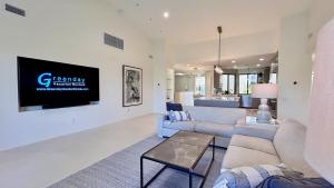 een woonkamer met banken en een tv aan de muur bij The Suite Spot in Rancho Mirage