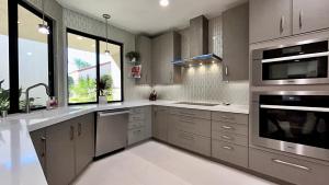 een grote keuken met roestvrijstalen apparatuur en ramen bij The Suite Spot in Rancho Mirage +35 foto's
