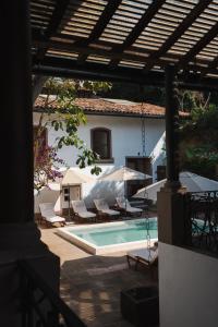 a swimming pool with chairs and umbrellas next to a house at Batucada Hotel Boutique in Valle de Bravo +14 photos