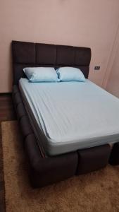 a bed with a leather frame with two pillows on it at Appt Fes centre ville in Fez
