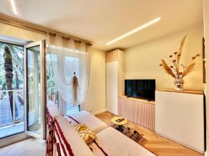 a living room with a couch and a large window at Studio Moderno Lungo Mare-ideale inverno in Menton +3 photos