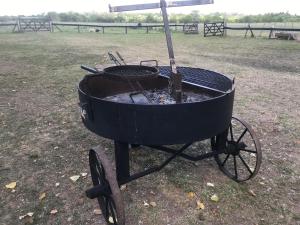 a black barbecue grill sitting in a field at La Pulperia in Capilla del Señor