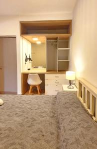 ein Schlafzimmer mit einem Bett und einem Schreibtisch mit einer Lampe in der Unterkunft Brescia departamentos in San Isidro