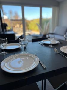 a table with plates and wine glasses on it at Dalabadets guesthouse in Trelleborg