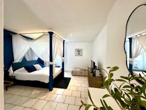 a bedroom with a bed with a blue canopy at Nuit En Brenne in Le Blanc