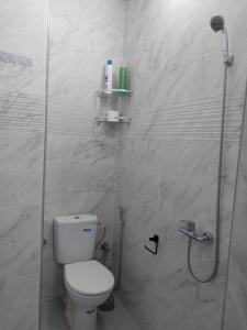 a white bathroom with a toilet and a shower at Casa Salvador 1 boujdour in Cabo Bojador