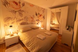 1 dormitorio con 1 cama grande y papel pintado de flores en Apt Matteucci 18 centro storico con parcheggio privato, en Rávena