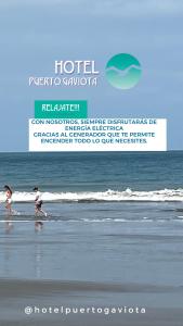 two children walking on the beach with a surfboard at Hotel Puerto Gaviota in Tonsupa