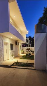 ein weißes Haus mit einem Tor davor in der Unterkunft Brescia departamentos in San Isidro