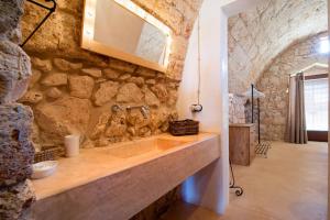 ein Steinbad mit einem Waschbecken und einem Spiegel in der Unterkunft Agriturismo Le Fornelle in Tricase