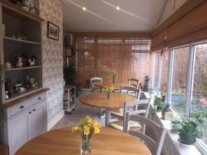 a kitchen and dining room with tables and chairs at Copperfields Guest House in Norwich