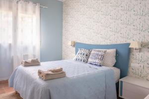 a bedroom with a blue bed with towels on it at Luxury villa close to beach, mountain and golf! in Alzira +31 photos