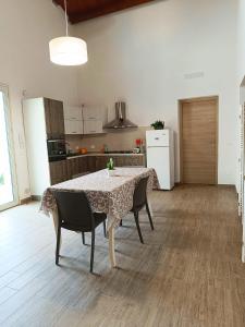 a kitchen with a table and chairs in a room at IL Casale di Petrosino in Petrosino