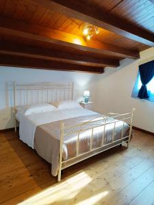 a bed in a bedroom with a wooden ceiling at IL Casale di Petrosino in Petrosino +26 photos