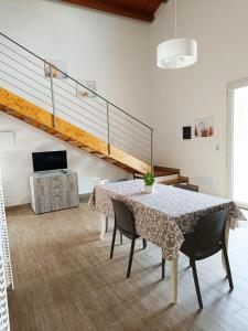 a dining room with a table and a staircase at IL Casale di Petrosino in Petrosino