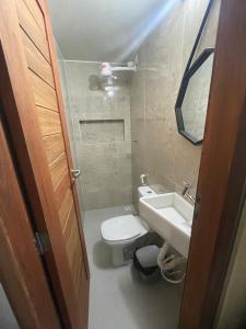 a small bathroom with a toilet and a sink at Brisa - Praia da Pipa in Pipa