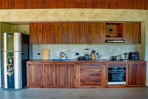 eine Küche mit Holzschränken und einem Kühlschrank in der Unterkunft Hotel Anukwe in Bonda