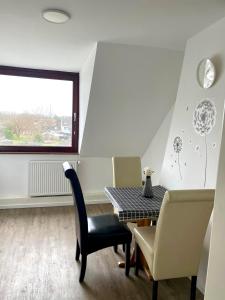 a dining room with a table and chairs and a window at HomeBerg Duisburg - feine 3 Zimmer, 4 Betten, 60qm in Top Lage in Duisburg