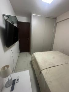 una piccola camera con letto e televisore di Flat luxo Shopping Rio Mar - Beach class Boa Viagem Recife - Piscina Rooftop a Recife