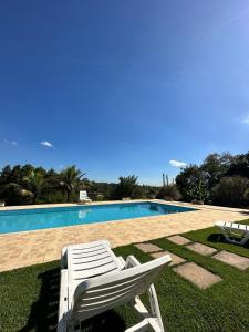 a white lounge chair sitting next to a swimming pool at Lindo sítio em porto feliz in Pôrto Feliz