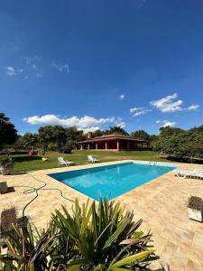 a swimming pool in front of a house at Lindo sítio em porto feliz in Pôrto Feliz