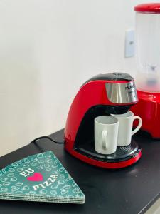 a toaster and two coffee cups on a counter at Studio Vista Linda 2 - Acesso a Riviera e Centro Kitnet in Bertioga