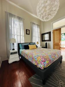 a bedroom with a large bed and a chandelier at Creole Cottage Uptown in New Orleans
