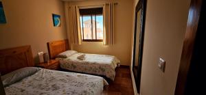 a small bedroom with two beds and a window at Ático con vistas al Mediterráneo in Isla Plana +18 photos