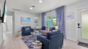 Una sala de estar con sillas azules y un sofá. en Ocean Drive Villas- Unit A, en Fort Pierce