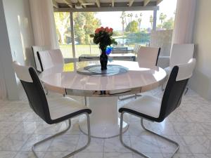 a white table with chairs and a vase with flowers on it at Cloud Nine in Rancho Mirage