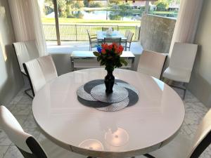 a white table with a vase with flowers on it at Cloud Nine in Rancho Mirage