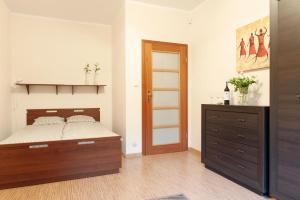 a bedroom with a bed and a wooden dresser at Apartament TSO Parkowa Polana in Polanica-Zdrój
