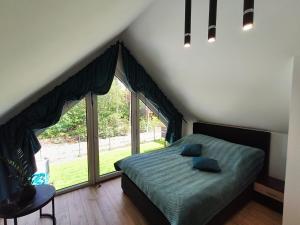 una camera da letto con un letto e una grande finestra di Holiday Hossa House 391 - całoroczne domy z Jacuzzi Sława a Sława
