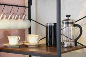 a coffee maker and two cups on a shelf at Historic Orlando Casita Love Apt A with backyard in Orlando