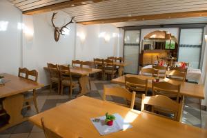 une salle à manger avec des tables et des chaises en bois dans l'établissement Hirschen B&B, à Maienfeld