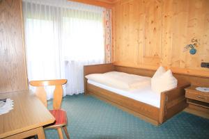 a small bedroom with a bed with a window at Berghaus Maria in Pettneu am Arlberg