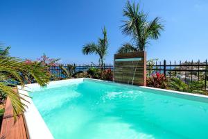 a swimming pool with a fence and palm trees at Casa Vanora in Garita
