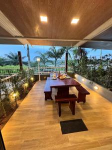 a dining table on a deck with a view of the ocean at Apartamento de um quarto com varanda externa in Bananeiras