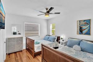 a bedroom with two beds and a ceiling fan at Dream Hollywood Beach Retreat With Jacuzzi and Fire Pit in Dania Beach